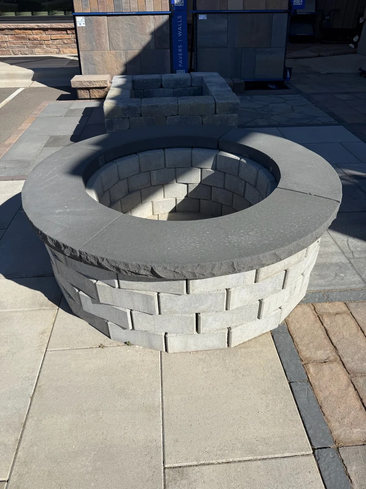 Round stacked-stone fire pit set into a paver patio